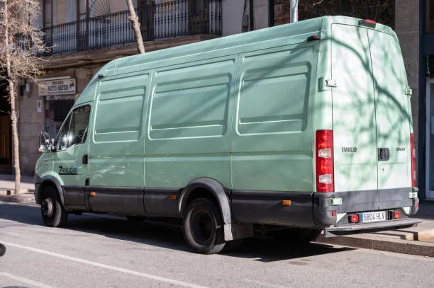 Large green iveco daily delivery van parked on the streets of the city of barcelona