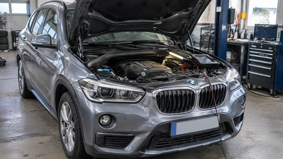 BMW X1 mit geöffneter Motorhaube und Diagnosegerät