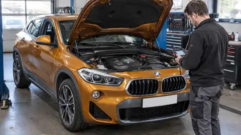 BMW X2 sDrive18i mit geöffneter Motorhaube bei der Motor- und FIN-Prüfung