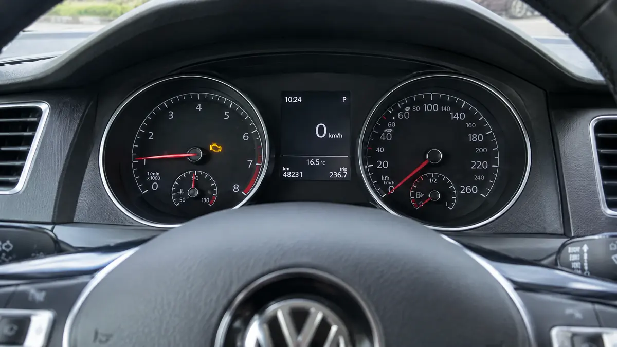 Gelbe Motorkontrollleuchte im Instrumentenbrett eines stehenden Volkswagen