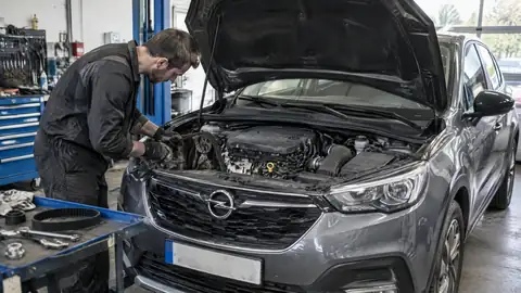 Mechaniker prüft den Zahnriemen eines Opel 1.2 Liter Dreizylinders