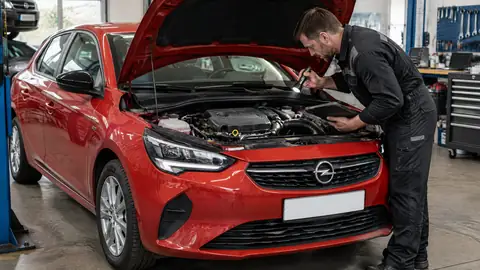 Opel Corsa F 1.2 mit geöffnetem Motorraum und Prüfung des Zahnriemens